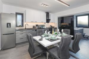 een keuken en eetkamer met een tafel en stoelen bij Villa Rene in Jadranovo
