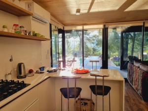 eine Küche mit einer Theke mit Hockern drum herum in der Unterkunft Colores de Manantiales in Villa General Belgrano + 2 Fotos