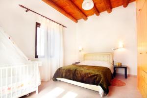 a white bedroom with a bed and a window at Villa Zourva in Zoúrva