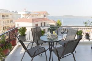 a patio with a table and chairs on a balcony at Mangata Apartment in Preveza