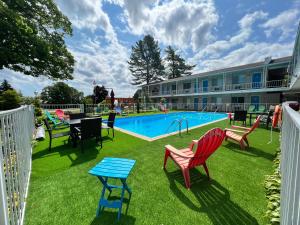 a pool with chairs and a table next to a building at American Boutique Inn - Lakeview in Mackinaw City