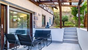 a patio with chairs and a table and stairs at Becks schöne Ferienwohnung in Vogtsburg