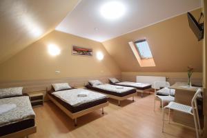 Cette chambre comprend 3 lits, une table et des chaises. dans l'établissement Pensjonat Paskal, à Czerlejno