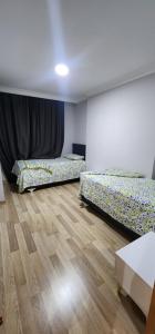 two beds in a room with wooden floors at Baris Mah, Kardelen Sk. BekTek Sit, N.12 B1 K.12 D.24 Beylikduzu/istanbul 34520 Turkey in Beylikduzu
