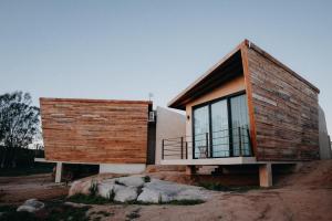 una casa con una fachada de madera en una colina en Paraje Hotel de Campo, en Ensenada