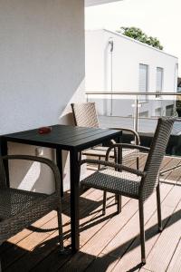 uma mesa preta e cadeiras numa varanda em Dill Apartments Stederdorf em Peine