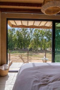 a bedroom with a bed and a large window at Paraje Hotel de Campo in Ensenada
