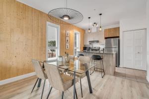 a dining room and kitchen with a glass table and chairs at Initial / Lapin / Downtown Qc in Quebec City