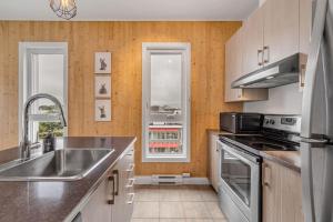 a kitchen with a sink and a stove at Initial / Lapin / Downtown Qc in Quebec City