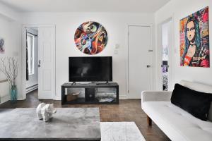 een woonkamer met een witte bank en een tv bij FREE PARKING and CENTRAL location in Montreal