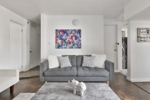 een woonkamer met een bank en een hond op een tapijt bij FREE PARKING and CENTRAL location in Montreal