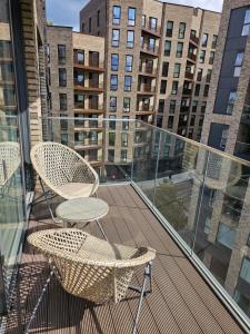 - un balcon avec deux chaises et certains bâtiments dans l'établissement Santina Apartments, à Croydon