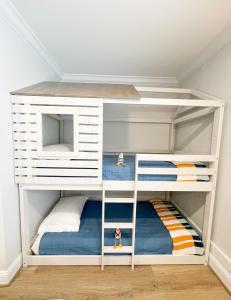 a white bunk bed with two bunk beds in a room at Retreat at Fenwick in Leonardtown