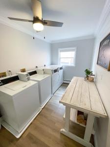 a laundry room with white appliances and a wooden table at Retreat at Fenwick in Leonardtown