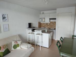 ein Wohnzimmer mit Sofa und eine Küche in der Unterkunft Duplex Le Reflet du Lac in Malbuisson