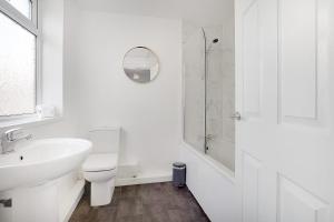 a white bathroom with a toilet and a sink at Delightful Home in Seaham, Sleeps 4 in Seaham