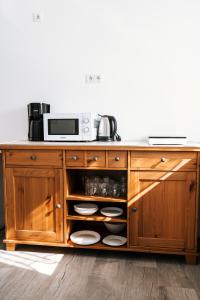 a wooden cabinet with a microwave on top of it at Dill Apartments Stederdorf in Peine