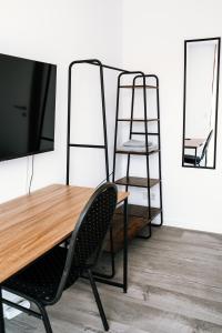 a table with a chair and a tv and a ladder at Dill Apartments Stederdorf in Peine