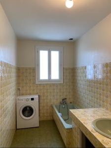 a bathroom with a washing machine and a sink at Maison Colonel Teyssier in Albi +12 photos