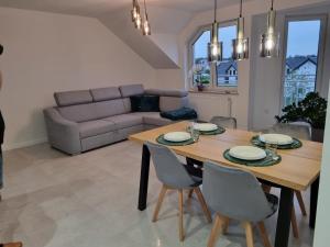 a living room with a wooden table and chairs at Apartament C22 in Darłowo