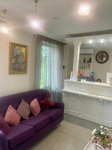 a living room with a purple couch and a counter at Boutique Hotel Deluxe in Kamianets-Podilskyi