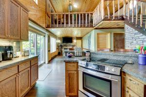 a kitchen with wooden cabinets and a stove top oven at Lakefront Outing Home Private Dock and Volleyball! in Emily