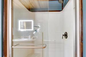 a shower with a glass door next to a sink at Lakefront Outing Home Private Dock and Volleyball! in Emily +31 photos