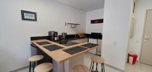a kitchen with a wooden counter and stools in it at Port FREJUS OPEN 2 pieces 40m2 in Fréjus