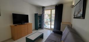 a living room with a couch and a flat screen tv at Port FREJUS OPEN 2 pieces 40m2 in Fréjus