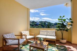 sala de estar con sillas y ventana grande en MARBELLA BANUS SUITES - La Quinta Cosy Flat With Fantastic Terrace, en Benahavís