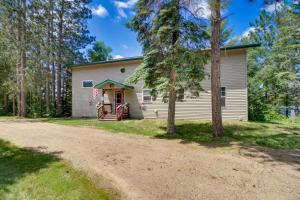 a house with a dirt road in front of it at Lakefront Outing Home Private Dock and Volleyball! in Emily