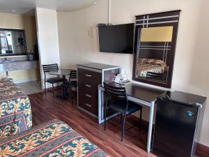 a hotel room with a desk and a mirror at Colonial Inn Hammond in Hammond