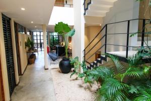 a hallway with plants and a staircase in a house at Unaluna by Rotamundos in Tulum