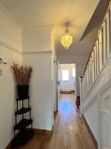 un corridoio di una casa con lampadario pendente di Large whole house with 7 bedrooms in S.Norwood a Norwood