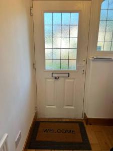 una porta con un tappetino di benvenuto davanti di Large whole house with 7 bedrooms in S.Norwood a Norwood