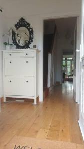 a room with a white dresser with a clock on it at Large whole house with 7 bedrooms in S.Norwood in Norwood