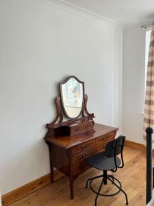 a desk with a mirror and a chair in a room at Large whole house with 7 bedrooms in S.Norwood in Norwood