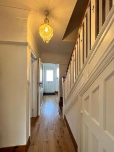 un corridoio di una casa con lampadario pendente di Large whole house with 7 bedrooms in S.Norwood a Norwood