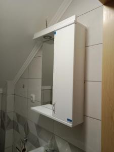 un armario blanco encima de un lavabo en el baño en Vila Tutić Apartman 1 i Apartman 2, en Mitrovac
