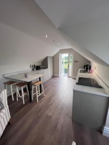 a white kitchen with a table and a counter top at Roe Retreat in Altmover