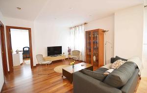 een woonkamer met een bank, een tafel en een televisie bij Precioso apartamento en Santander in Santander