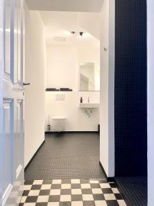 ein Bad mit schwarz-weiß kariertem Boden in der Unterkunft zehuus - historical charm 70qm in Köln