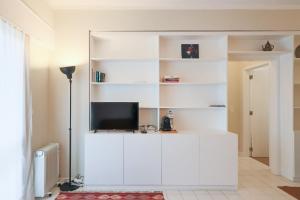 een woonkamer met witte planken en een televisie bij HM - Galiza Vilar Apartment in Porto