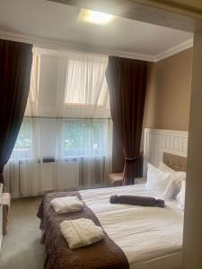 een slaapkamer met 2 bedden en een raam bij Boutique Hotel Deluxe in Kamjanets-Podilsky