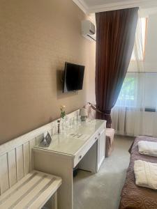 a room with a white desk with a tv on the wall at Boutique Hotel Deluxe in Kamianets-Podilskyi