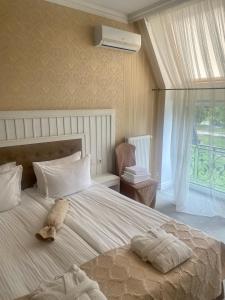 - une chambre dotée d'un grand lit avec un animal rembourré dans l'établissement Boutique Hotel Deluxe, à Kamianets-Podilsky