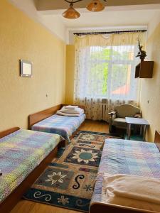 Habitación con 3 camas, ventana y alfombra. en Guesthouse Zarasai, en Zarasai