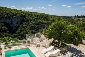 a villa with a swimming pool and a mountain at Masseria Sant'Elia Castellaneta in Castellaneta