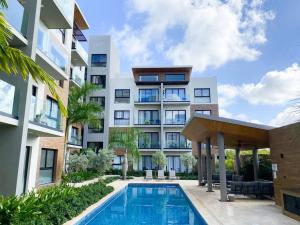 um edifício de apartamentos com uma piscina em frente em Thematic beach apartment in CapCana area em Punta Cana