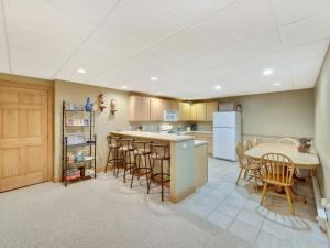 a kitchen with a table and chairs and a refrigerator at 689 Disciples Village Unit in Boyne Falls